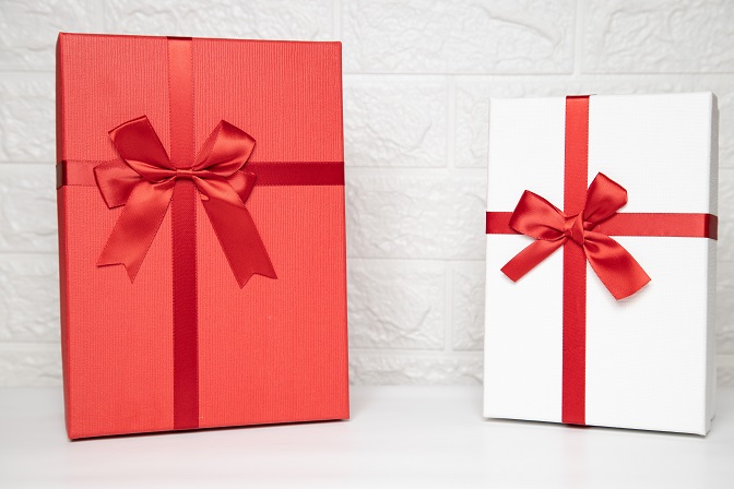 Białe i czerwone eleganckie pudełko na prezent przewiązane wstążką