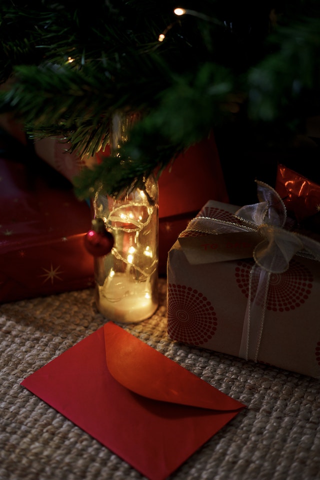 Świąteczny prezent, mała lampka i koperta.