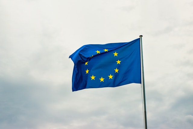 Flaga Unii Europejskiej na tle chmur.