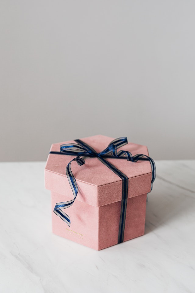 Różowe pudełko prezentowe z niebieską wstążką