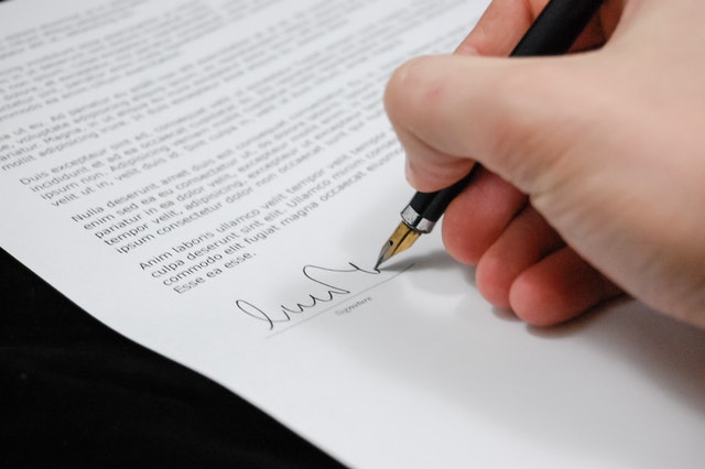 Dłoń podpisująca dokument.